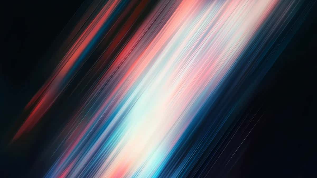 Diagonal streaks of red, pink, white, and blue light rays on dark background
