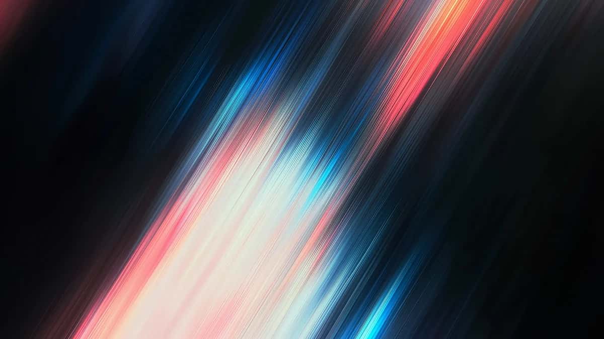 diagonal streaks of pink, blue, and white light blurring across dark background