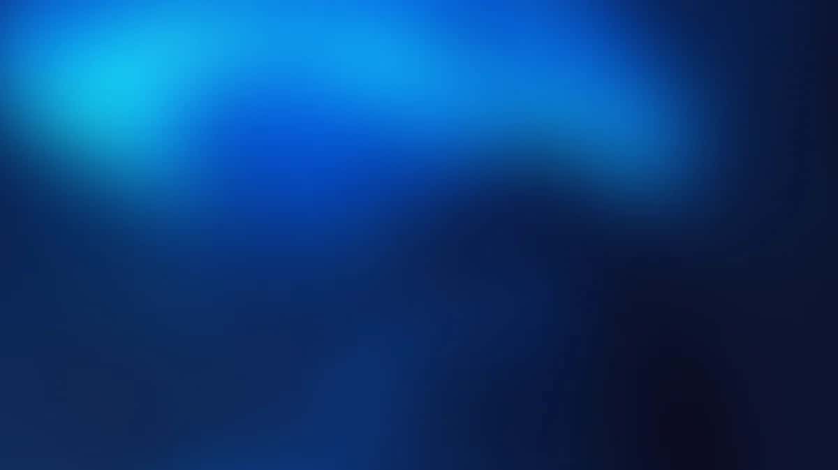Abstract blue gradient background with soft light glow and dark edges