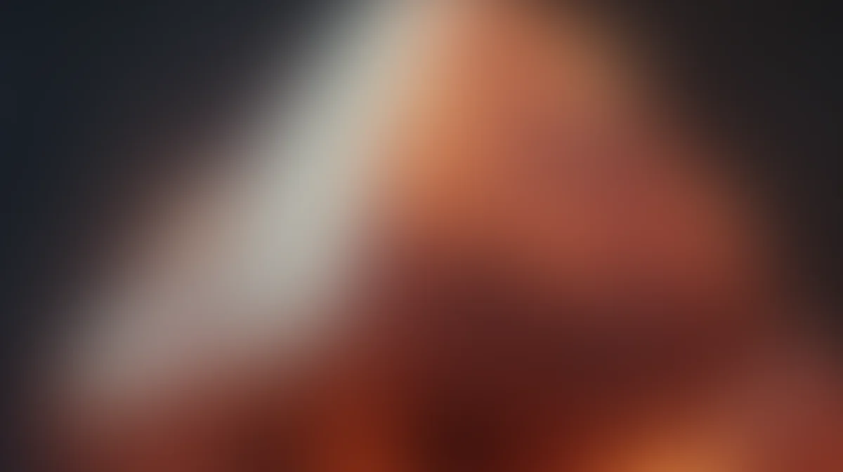 Abstract gradient background with warm orange and deep burgundy tones blending into dark shadows