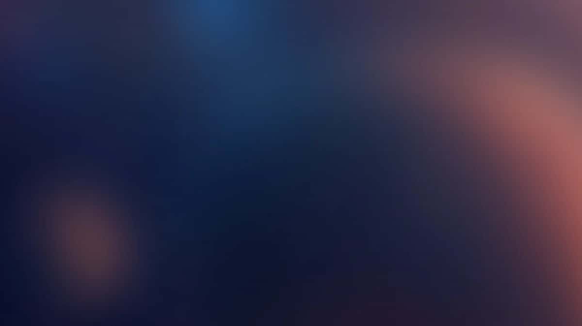 Abstract gradient background transitioning from deep blue to warm coral pink tones
