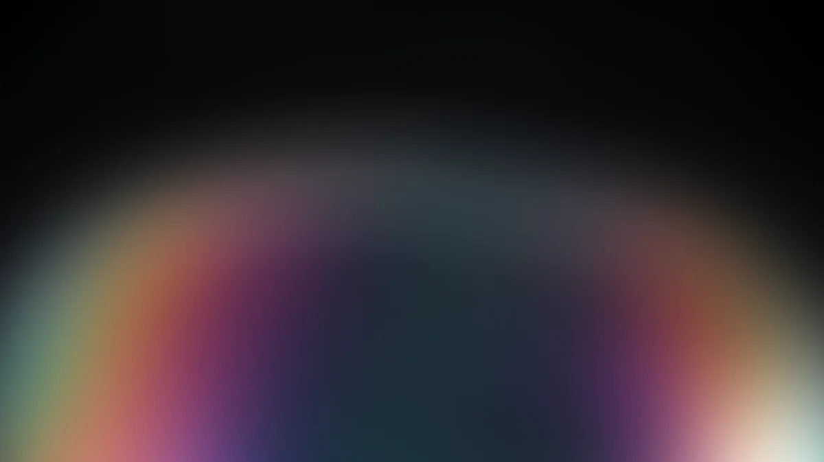 Soft radial gradient with rainbow spectrum fading to dark teal center, blurred bokeh effect
