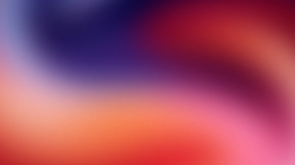Abstract gradient background blending deep purple, orange, red, and pink hues with soft blur
