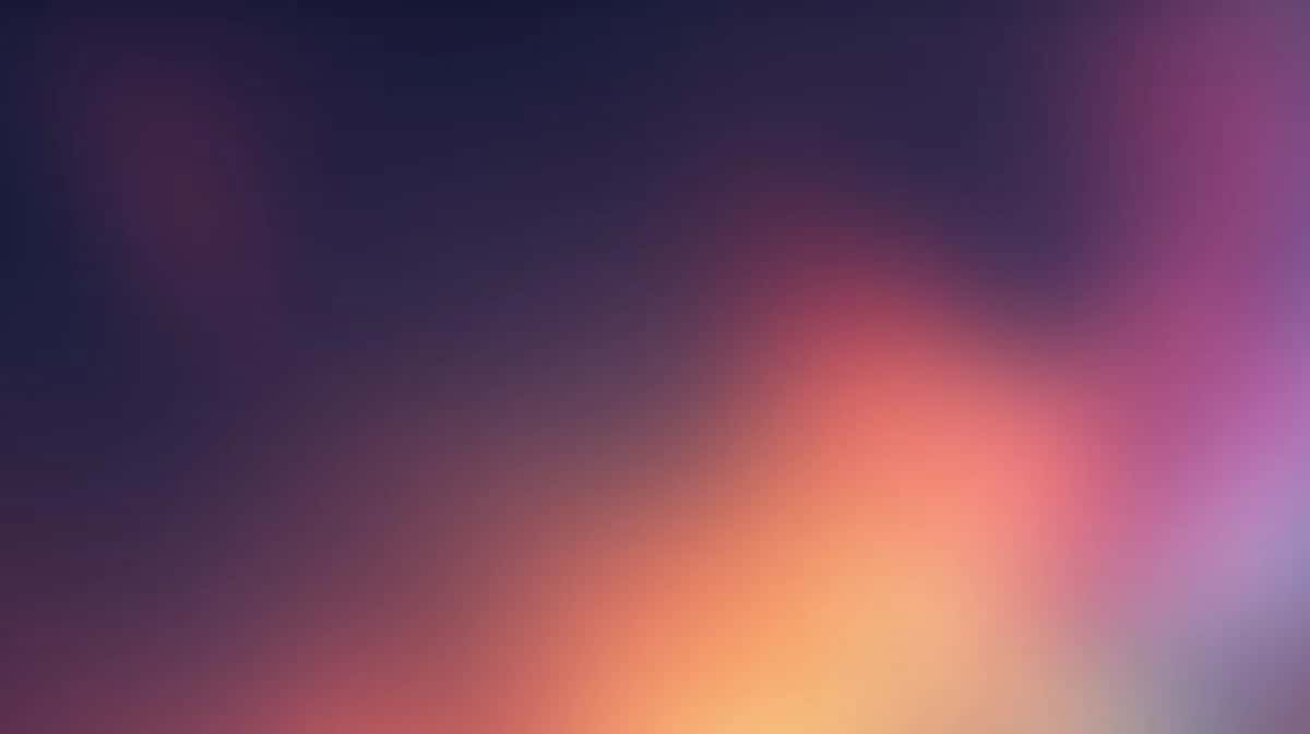 Abstract gradient background transitioning from purple and blue to warm orange and pink tones