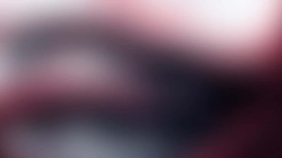 Abstract gradient background transitioning from deep burgundy and charcoal to soft pink and white