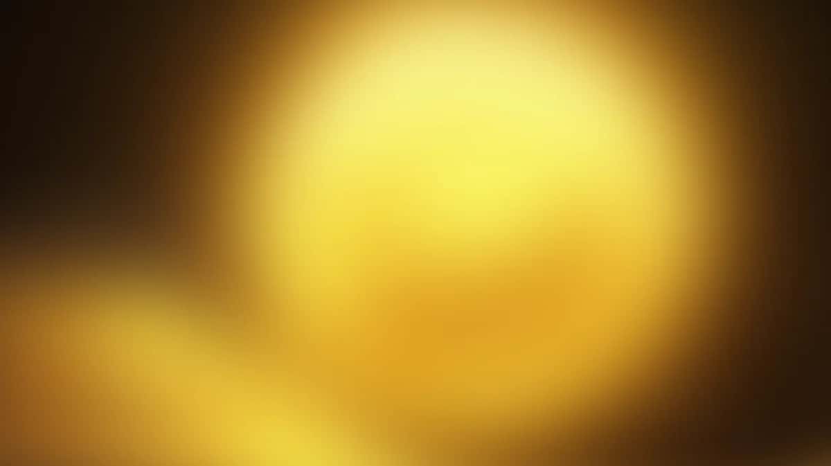 Blurred golden yellow gradient background with soft warm light and dark edges
