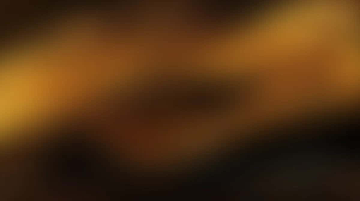 Abstract warm gradient background with golden amber and deep brown tones blending smoothly