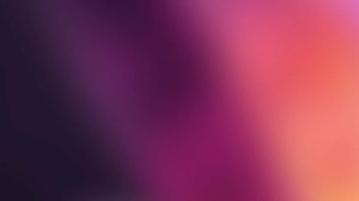 Abstract gradient wallpaper transitioning from deep purple to coral pink with soft blurred forms