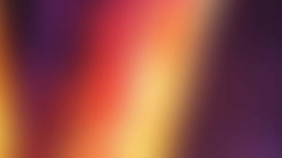 Vibrant gradient background transitioning from purple through red, orange, yellow to cream
