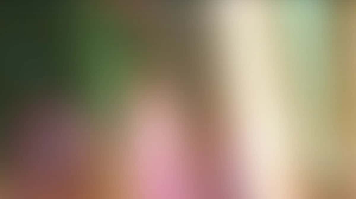 Soft blurred gradient background transitioning from green and pink to cream and beige tones