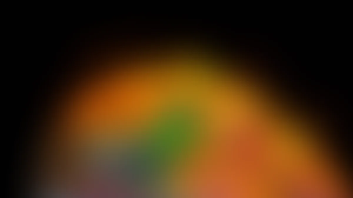 Abstract gradient background with warm orange, yellow, and green tones blending softly into darkness
