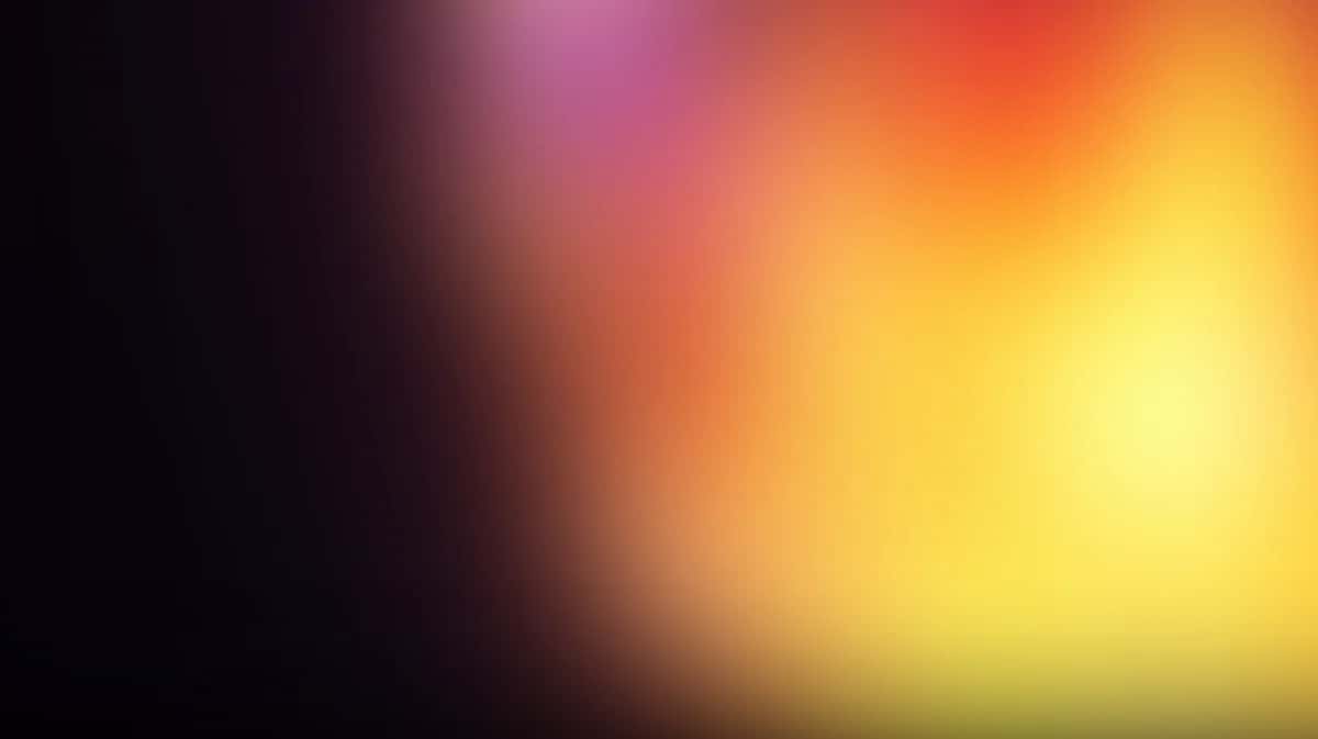 Hazy gradient glow shifting from dark plum to magenta, orange and bright yellow