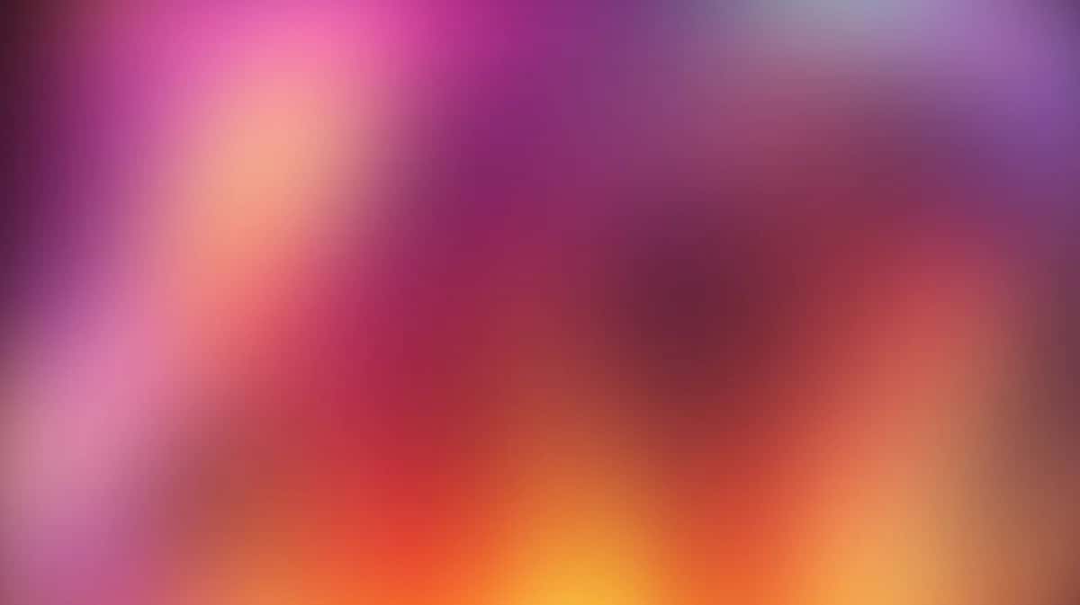 Abstract gradient background with pink, orange, yellow, and red blurred colors blending smoothly