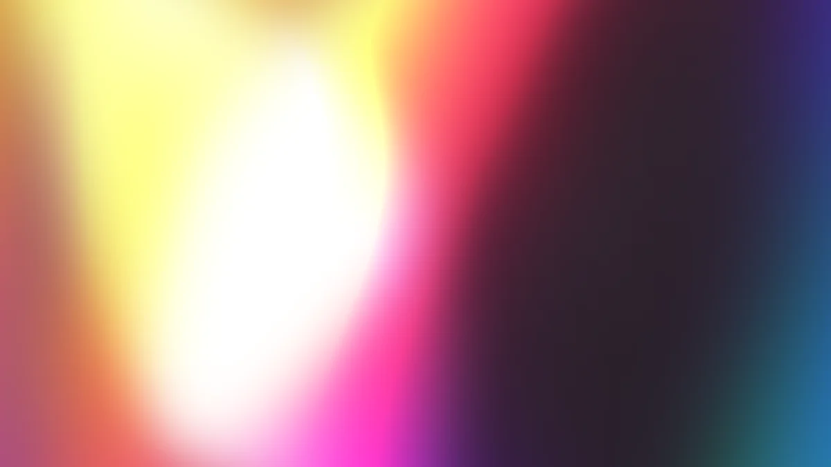 Soft gradient blur with white center transitioning through yellow, pink, magenta, and teal edges