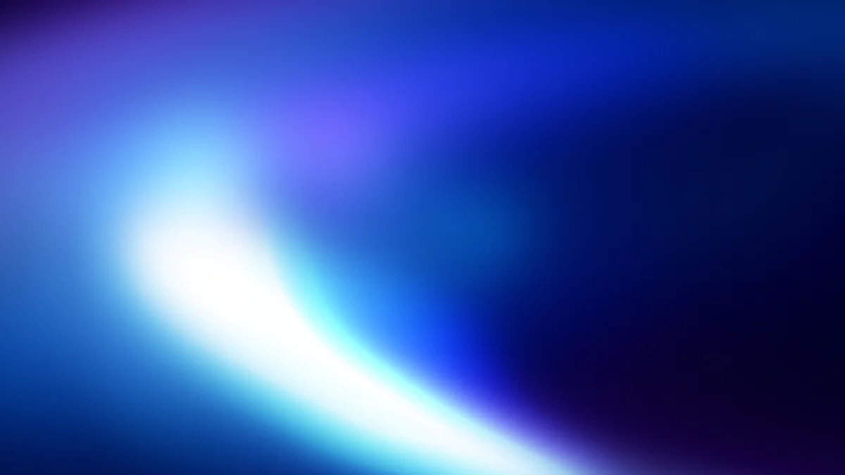 Abstract blue gradient with bright white light source, soft blurred glow, dark corners