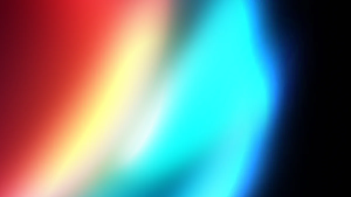 Abstract gradient blur transitioning from red and yellow to cyan and blue on black background
