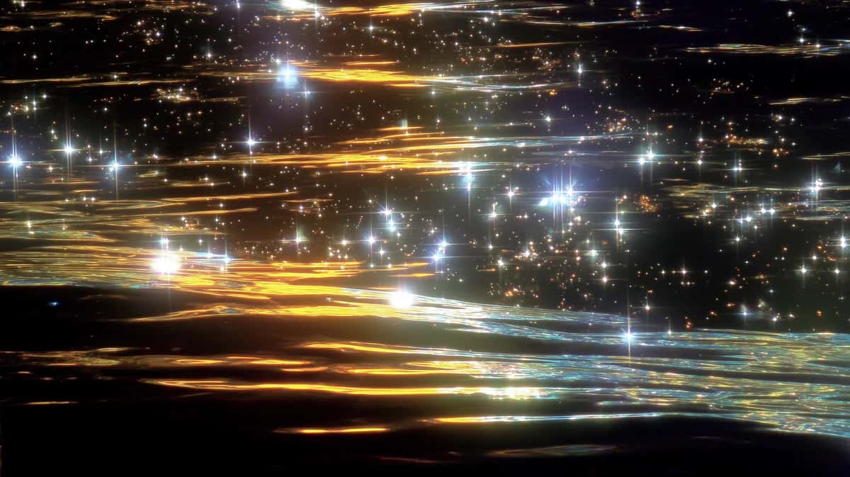 Abstract light trails and bokeh lights in gold, white, and dark tones with horizontal streaking motion