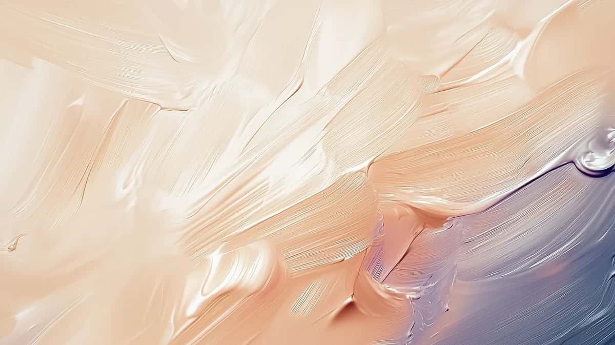 Abstract paint smudges blending cream, peach, and lavender tones with soft brushstrokes