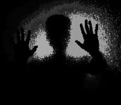 Grayscale dotted silhouette of a figure pressing both hands against frosted glass