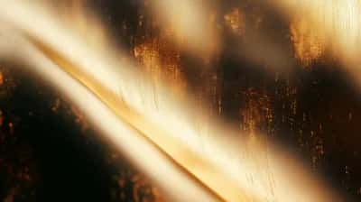 Diagonal golden light beams with scattered orange embers on dark grain
