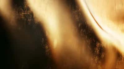 Soft amber light beams glowing behind a dusty textured glass surface