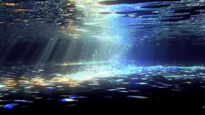 Underwater view with sunbeams piercing deep blue water above a bubble-filled seabed