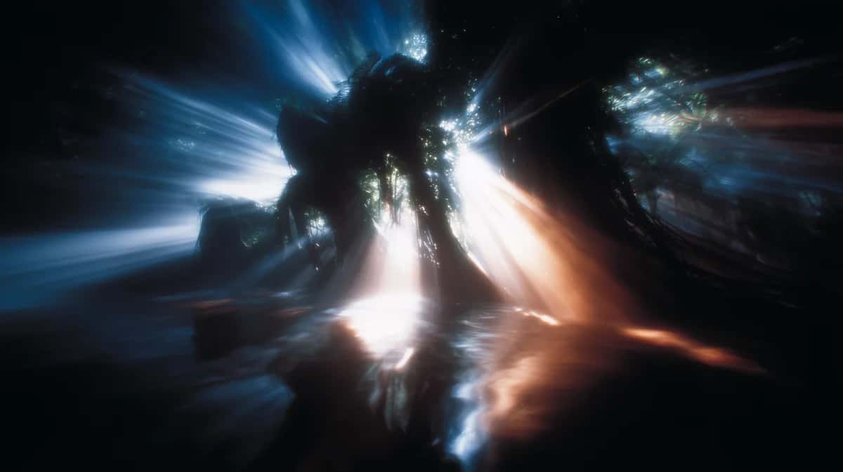 Abstract light burst with blue and orange rays emanating from luminous center, dark composition